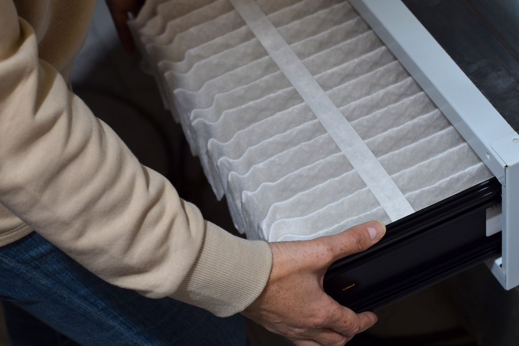 Woman changing air filter. | Parts Of Residential HVAC System