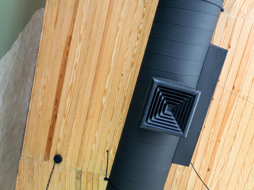 Black duct on ceiling of building. 