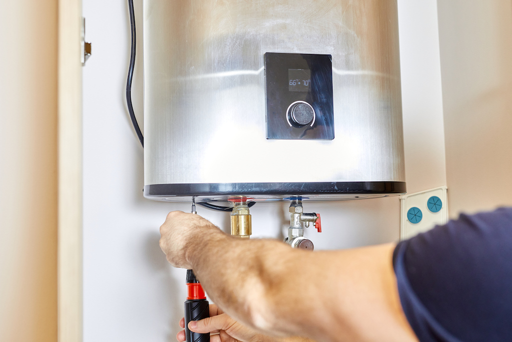 Man adjusting water heating system. | Central Heating Servicing