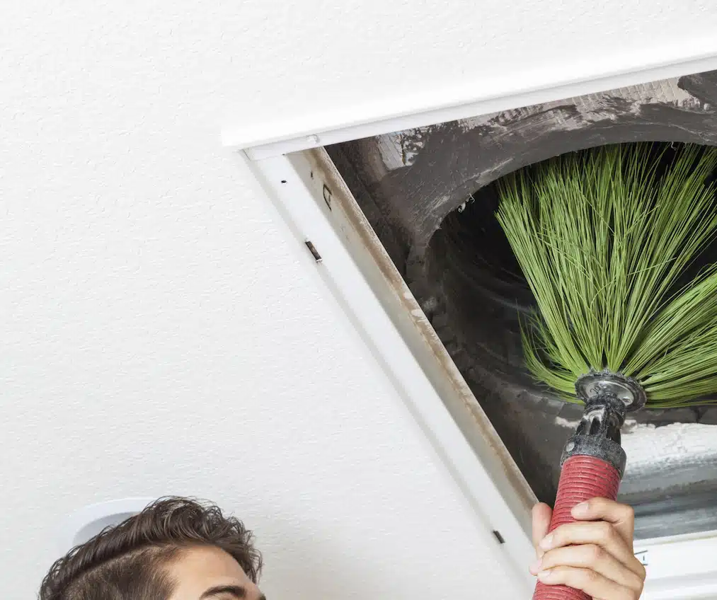 Man cleaning air ducts in home. Duct Cleaning