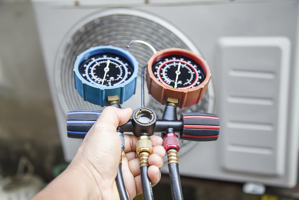 AC tech checking an ac unit with tools. Air Conditioner Installation