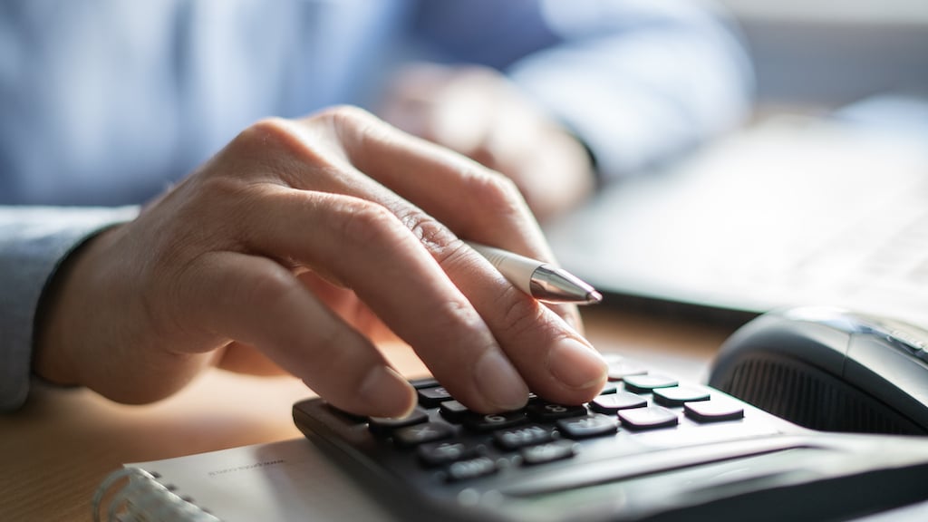 Person using calculator to determine cost of duct cleaning service.