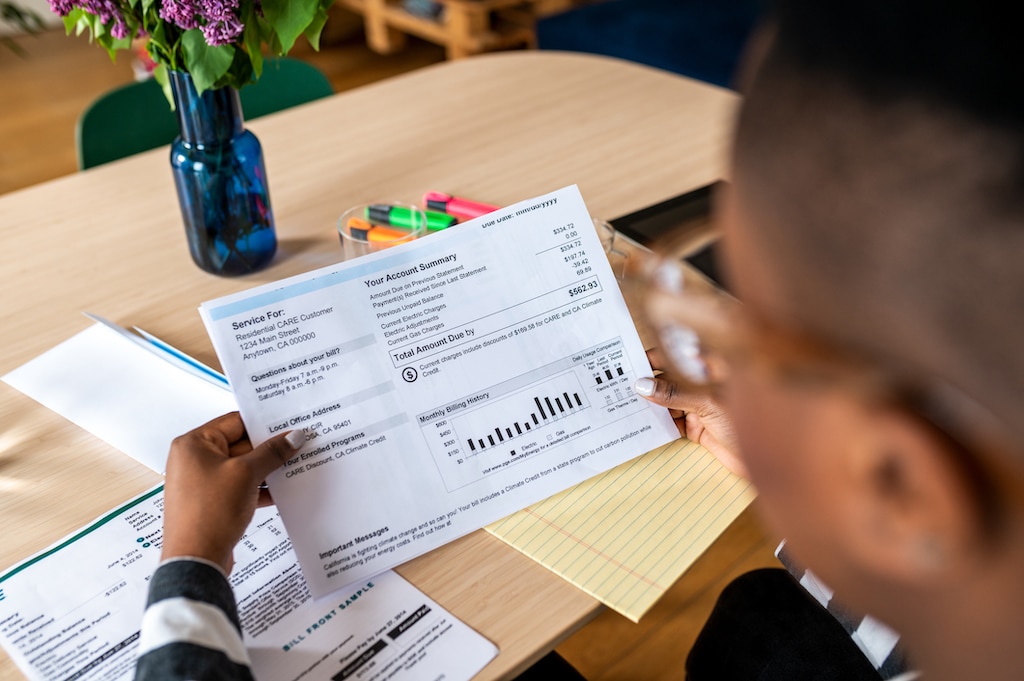 Woman looking at her high energy bill in Southlake due to needing heating and AC repair.