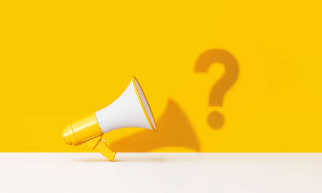 Bullhorn and question mark on yellow background. Representing FAQs about natural gas heating and cooling systems.