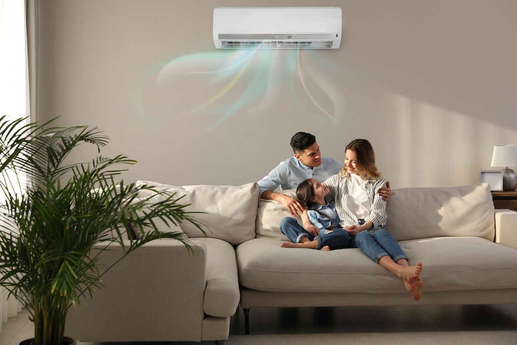 Family relaxing on couch under ac unit. | Air Conditioning Service