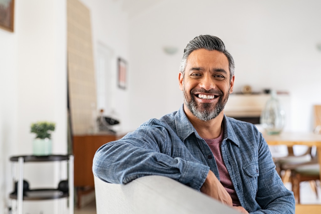 Happy man smiling into camera at home. Air conditioning service.