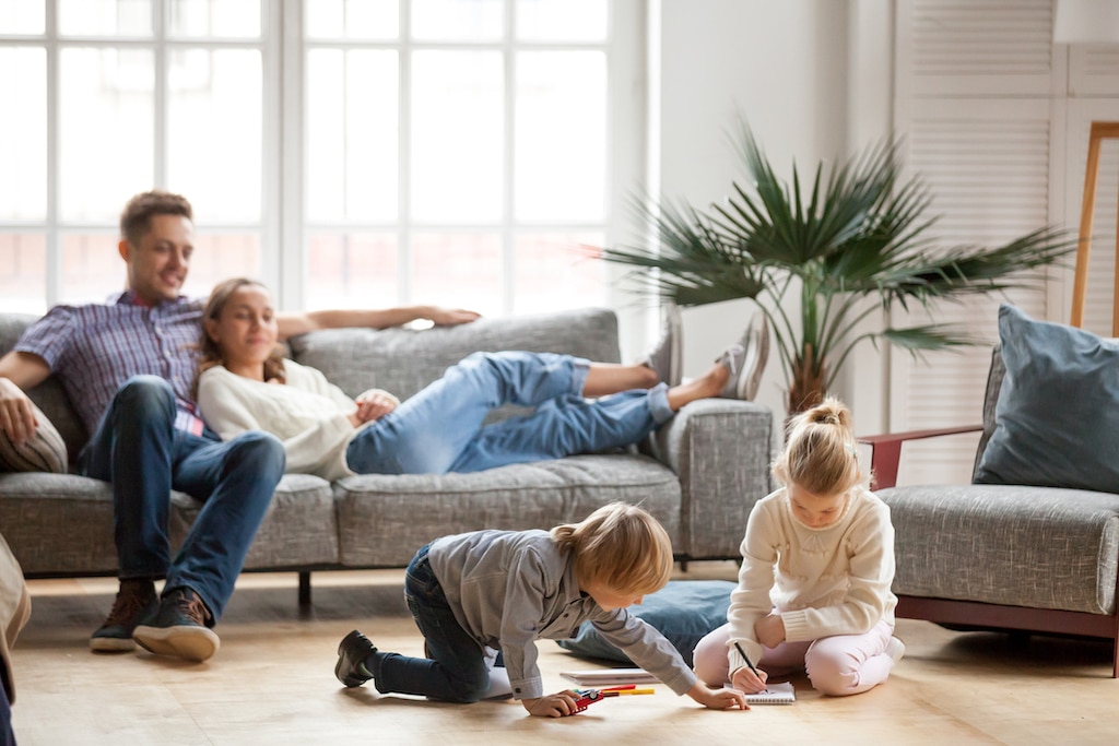 Happy family playing in living room comfortable thanks to their Hydro Air Heating System.