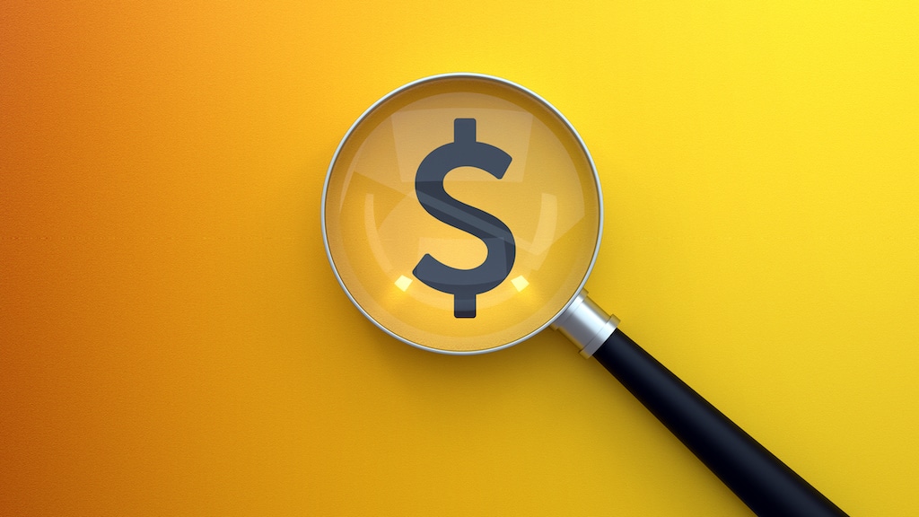 Magnifying glass with dollar sign on yellow background. Closed Loop Radiant Heat System.