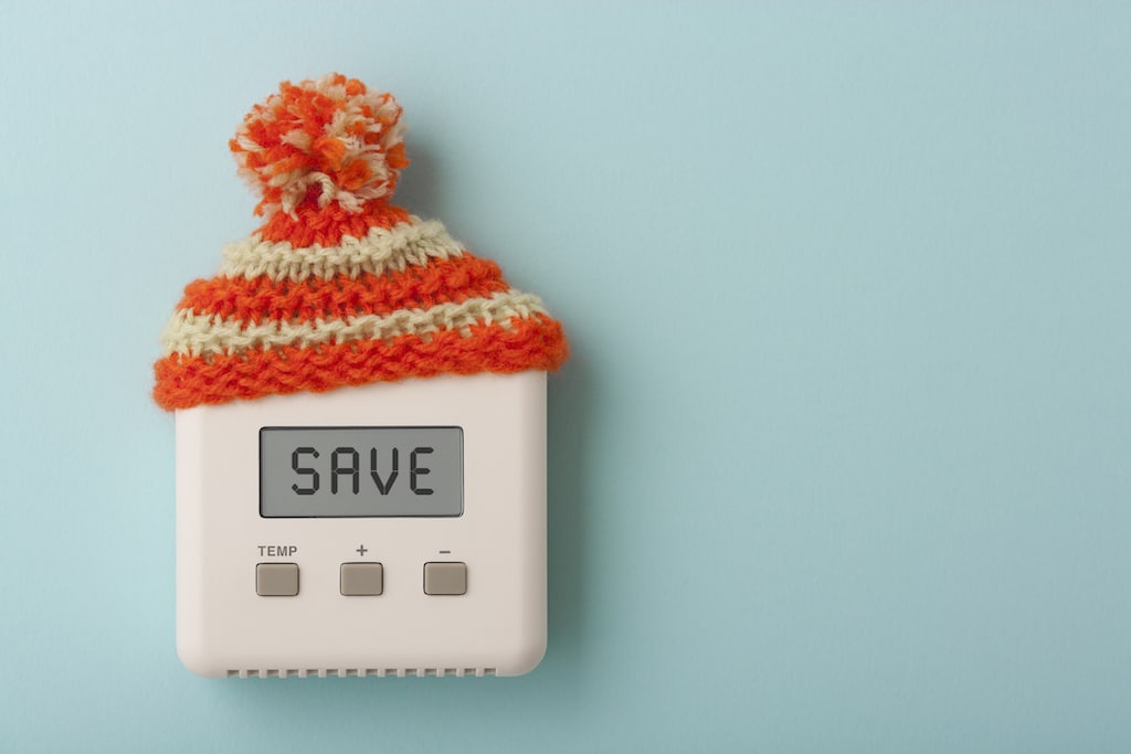 Thermostat with the word 'save' and a winter beanie. Closed Loop Radiant Heat System.