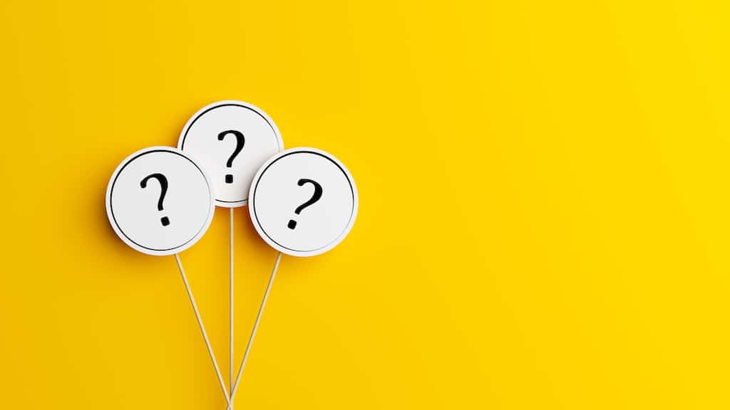 Three question marks on sticks with yellow background. 