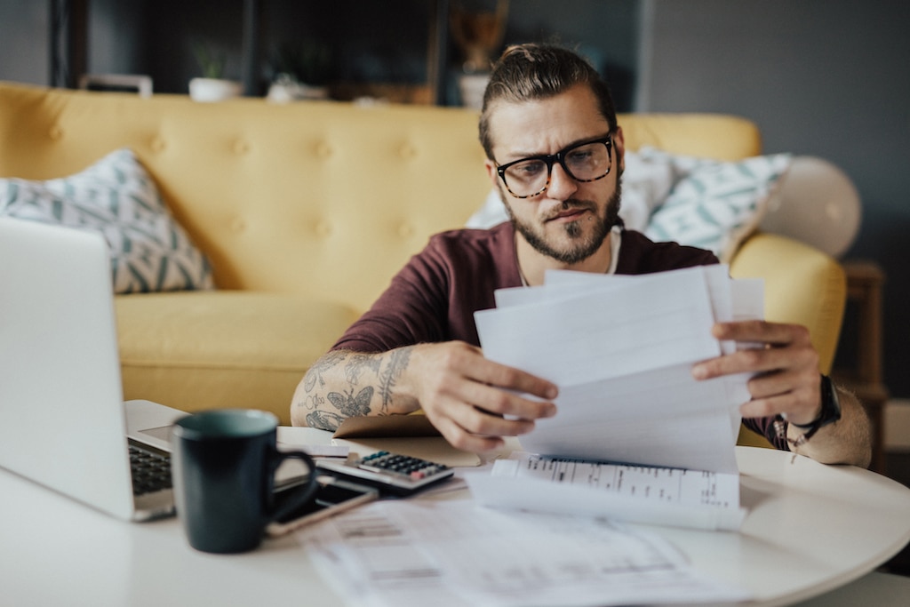 Man sitting on living room floor going over HVAC warranty. | AC Installation Checklist