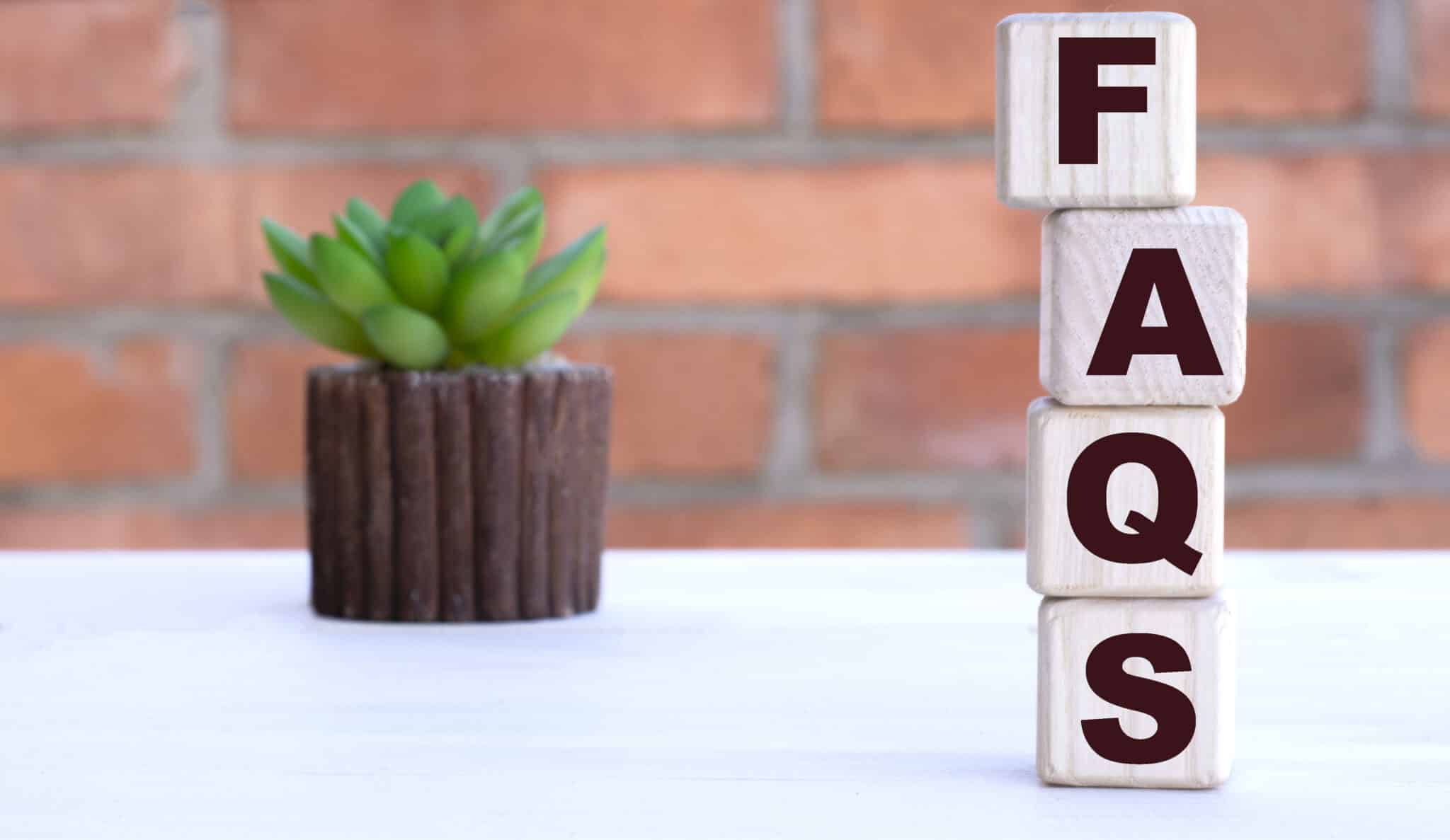 FAQS the word on cubes against the background of a brick wall with a cactus., HVAC Efficiency.