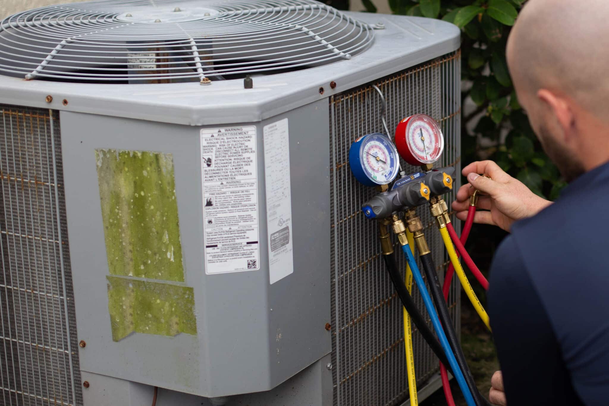 Mechanic working on an AC outdoors air-conditioner, Outdoor HVAC Units.