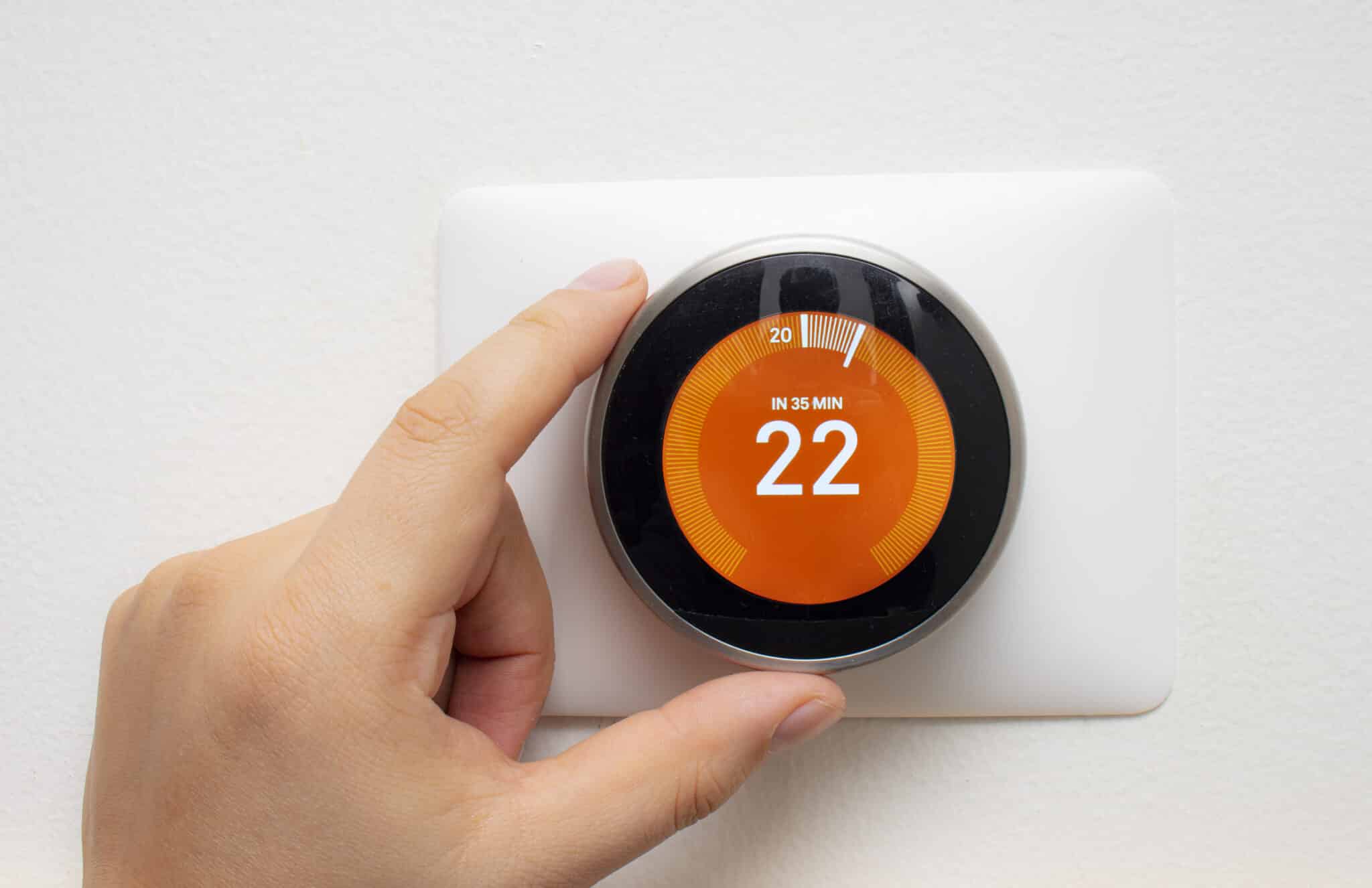 Smart Thermostat with a person warming up the room temperature with a soft shadow, Air Quality Improvements.