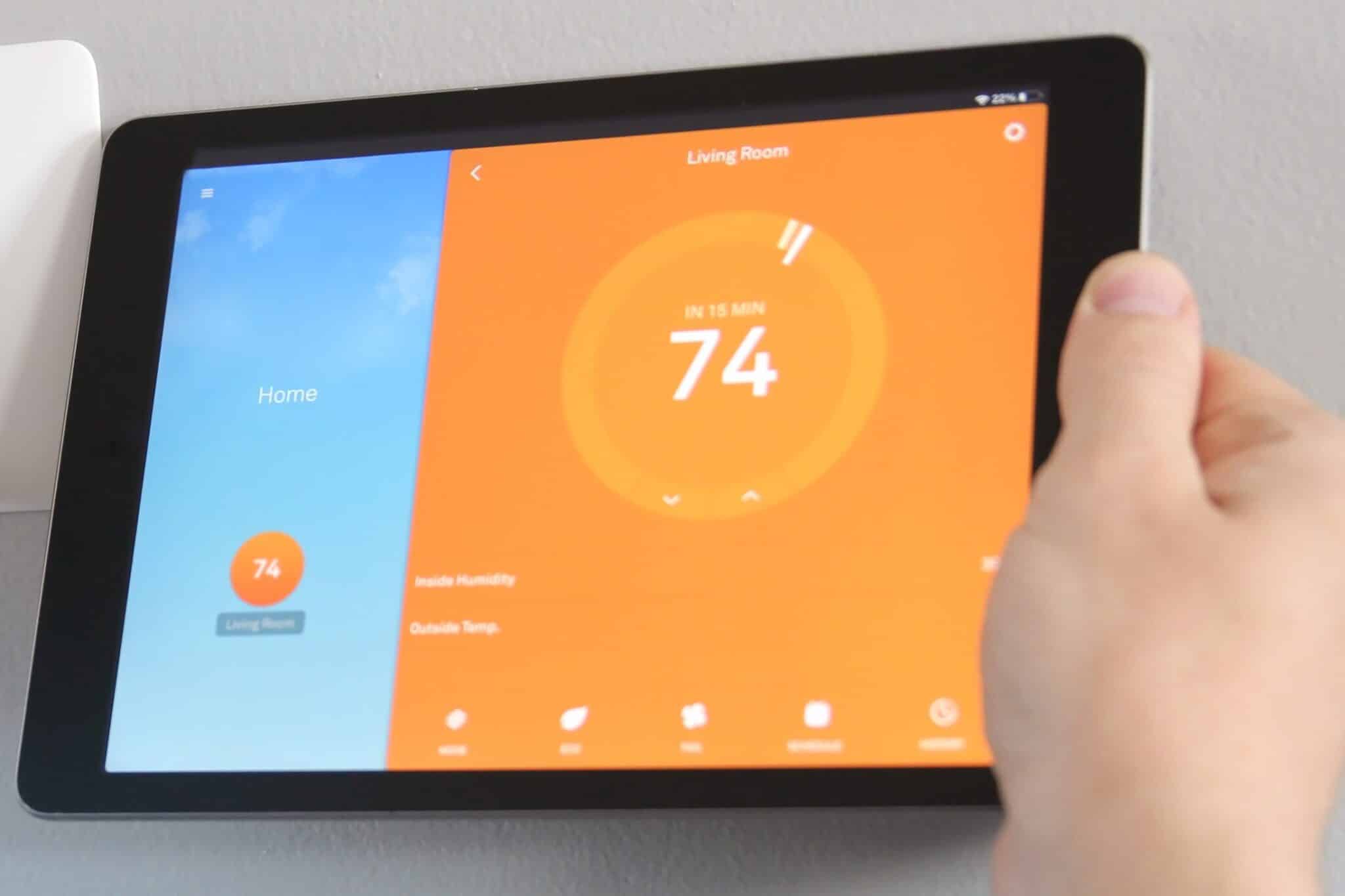 Adjusting a temperature using a tablet with smart home app, Best Thermostats.