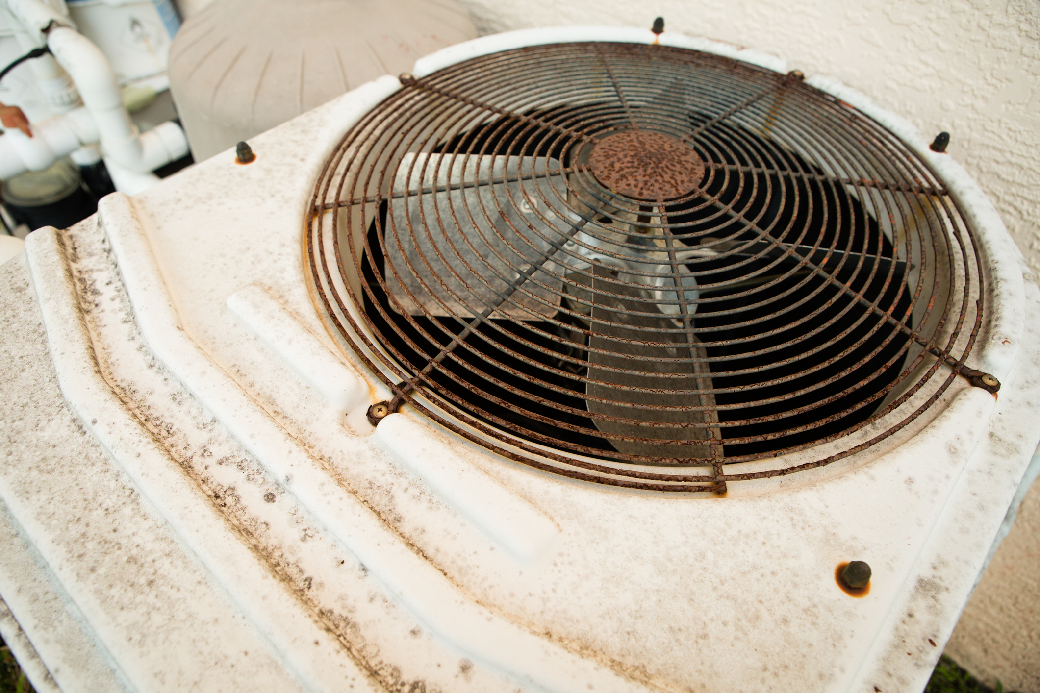 Rusted outdoor HVAC unit needing fan blade replacement.