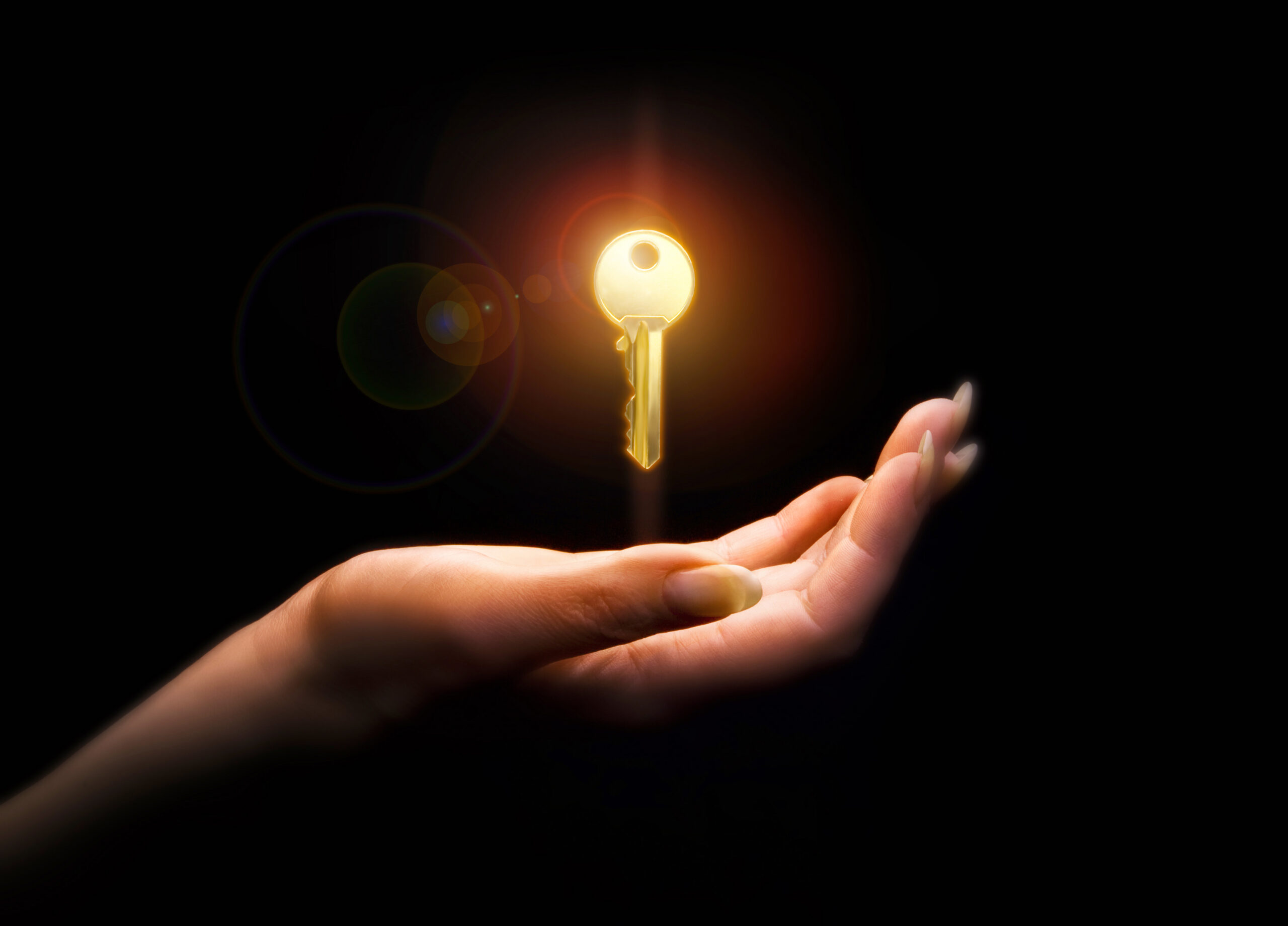 Thermostat locking cover key floating above a woman’s hand.