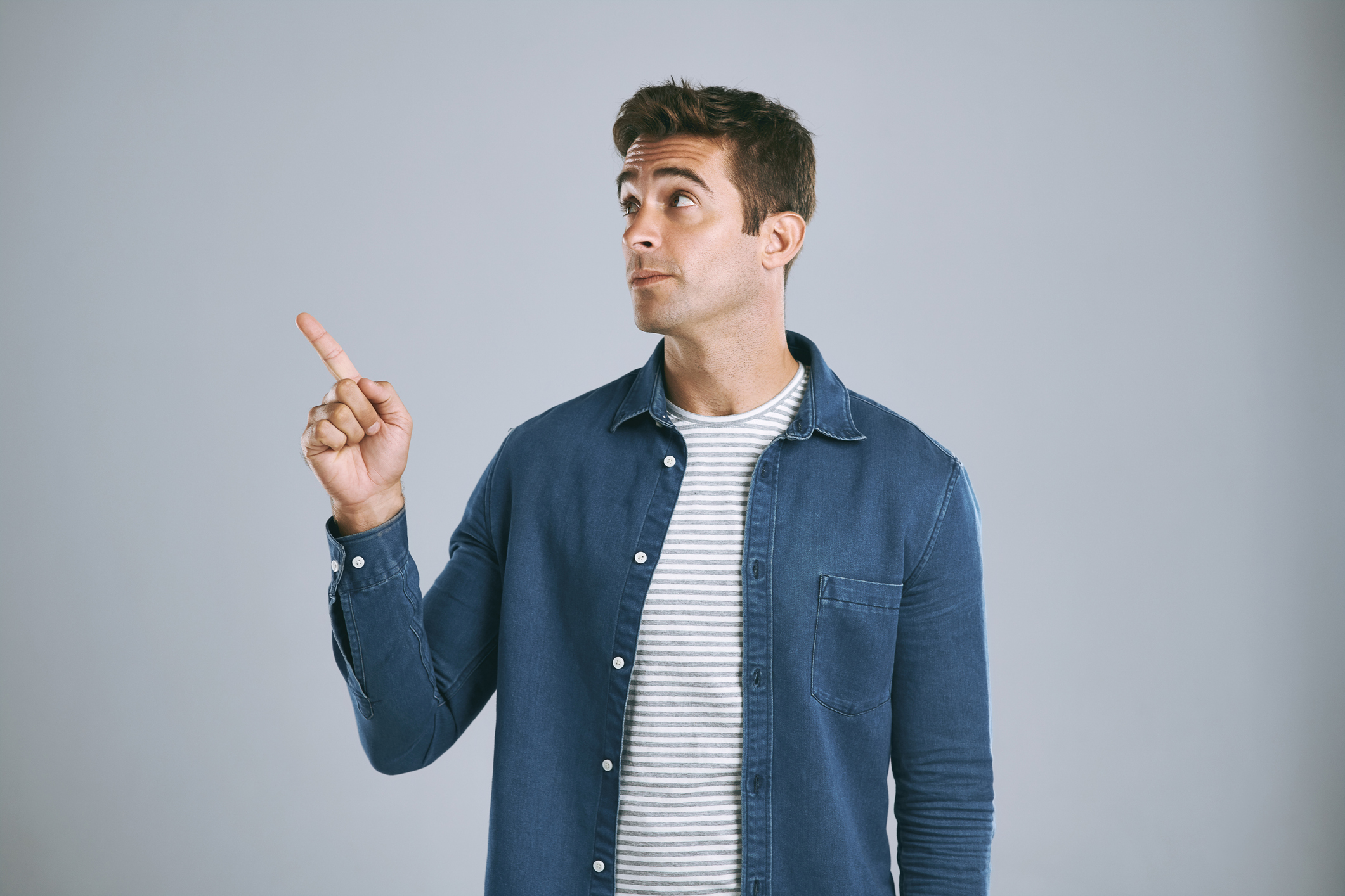 Man pointing up against a grey background, Fan blade pitch check.